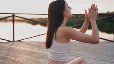 Young woman practicing yoga on the nature at sunset. active meditation a relax concept