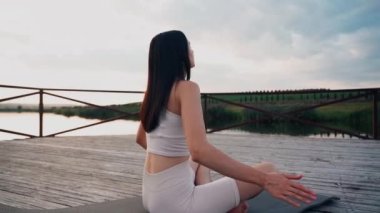 Young woman practicing yoga on the nature at sunset. active meditation a relax concept