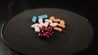 Pills and a syringe with a drug revolve on a black background. the concept of drug addiction, banditry and criminal case