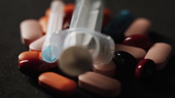 薬の入った薬と注射器は黒い背景で回転します 薬物依存症強盗犯罪という概念は — ストック動画