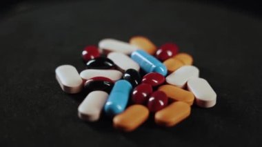 Pills and a syringe with a drug revolve on a black background. the concept of drug addiction, banditry and criminal case