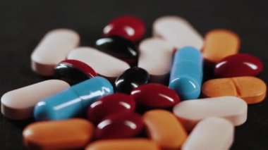 Pills and a syringe with a drug revolve on a black background. the concept of drug addiction, banditry and criminal case