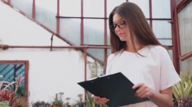 Woman biologist examines the growth and production of plants in a greenhouse. Biologist working on the creation of medicines for diseases.Biology concept