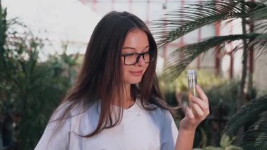 Woman biologist examines the growth and production of plants in a greenhouse. Biologist working on the creation of medicines for diseases.Biology concept