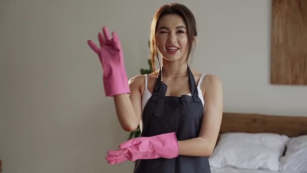清掃サービス自宅のリビングルームで女性労働者の清掃 美しい若い女の子の家政婦のクリーナーは エプロンを着用し 家事のための乱雑な汚い床を掃除します — ストック動画