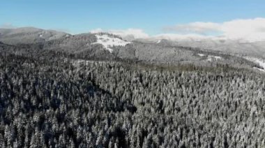 Sunny day in snow covered Carpathian Mountains. Clouds above clear sky 4k