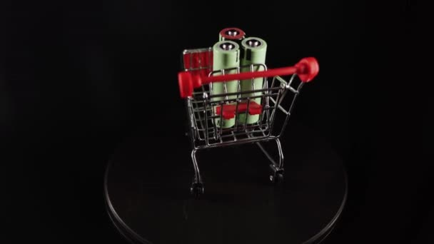 Oplaadbare Batterijen Een Winkelwagentje Draaien Een Zwarte Achtergrond — Stockvideo