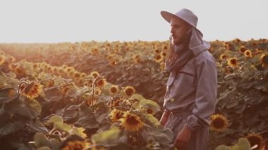 Genç arıcılar arılarla çalışır ve bal yerler.