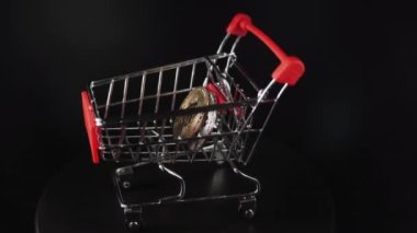 Altın bitcoin ya da kripto para ya da siyah arka plandaki alışveriş arabasındaki semboller. Gelecek para birimi kavramı.