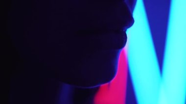 Ultraviyole ışıkta uzun saçlarıyla dans eden güzel bir kız.