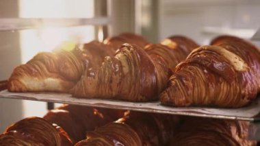 Kruvasanlar, ticari bir mutfakta kahvaltıda müşteriler için fırından çıktıktan sonra tepside. Fırında taze kruvasan satılıyor.