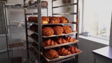 Kruvasanlar, ticari bir mutfakta kahvaltıda müşteriler için fırından çıktıktan sonra tepside. Fırında taze kruvasan satılıyor.