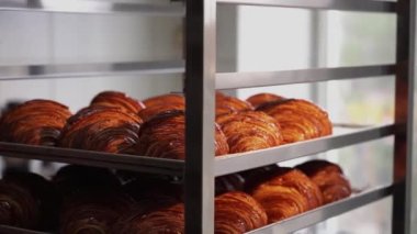 Kruvasanlar, ticari bir mutfakta kahvaltıda müşteriler için fırından çıktıktan sonra tepside. Fırında taze kruvasan satılıyor.