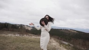 İlkbaharda Avrupa 'da bir dağın zirvesinde genç ve çekici bir kadın. Doğanın tadını çıkar.