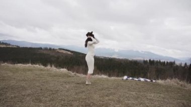 İlkbaharda Avrupa 'da bir dağın zirvesinde genç ve çekici bir kadın. Doğanın tadını çıkar.