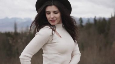 İlkbaharda Avrupa 'da bir dağın zirvesinde genç ve çekici bir kadın. Doğanın tadını çıkar.