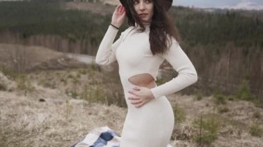 İlkbaharda Avrupa 'da bir dağın zirvesinde genç ve çekici bir kadın. Doğanın tadını çıkar.