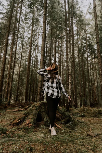 stock image Stylish hipster woman in a hat posing in a pine forest.Travel concept