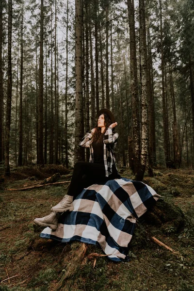 stock image Stylish hipster woman in a hat posing in a pine forest.Travel concept