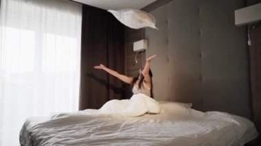 Genç bir kadın yatakta uyuyor, sabah uyanıyor. Sağlıklı bir uyku konsepti.