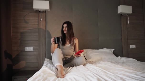 Happy Uśmiechnięta Kobieta Pomocą Smartfona Dinking Gorącej Kawy Rano Łóżku — Wideo stockowe