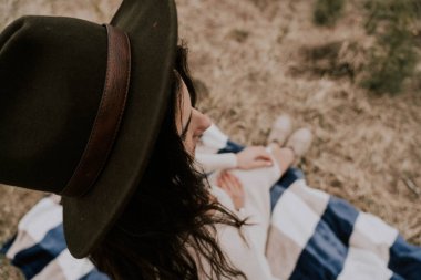 Karlı Karpatya dağlarının arka planında şapkalı bir kadın gezginin portresi