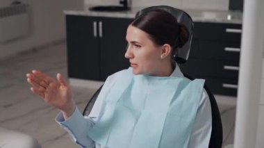 Diş kliniğinde koruyucu maskeli iki doktor hasta kıza hizmet ediyor. İş Dişçiliği. Sağlık ve Tıp Konsepti.