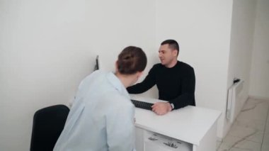 Diş kliniğinde koruyucu maskeli iki doktor hasta kıza hizmet ediyor. İş Dişçiliği. Sağlık ve Tıp Konsepti.