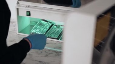 Diş kliniğinde koruyucu maskeli iki doktor hasta kıza hizmet ediyor. İş Dişçiliği. Sağlık ve Tıp Konsepti.