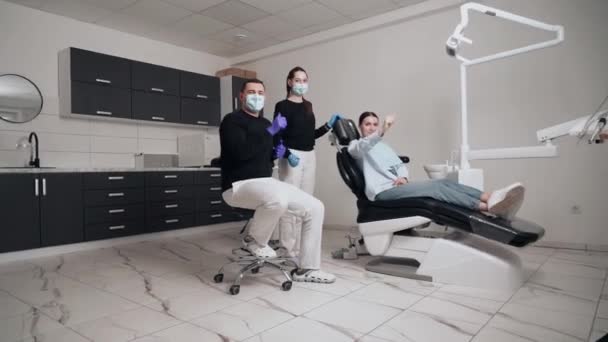 Diş Kliniğinde Koruyucu Maskeli Iki Doktor Hasta Kıza Hizmet Ediyor — Stok video