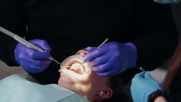치과에서 보호용 마스크를 가환자에게 도움을 베풀고 일하는 — 비디오