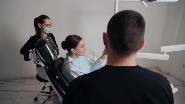 Dva Doktoři Muž Žena Ochranných Maskách Zubní Klinice Slouží Pacientce — Stock video