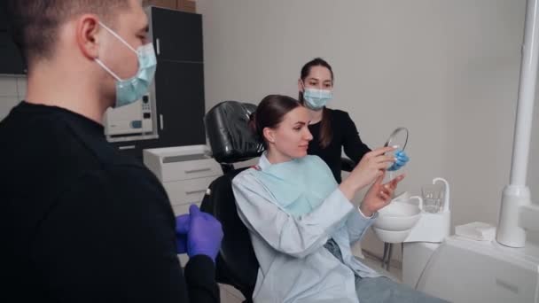 Dva Doktoři Muž Žena Ochranných Maskách Zubní Klinice Slouží Pacientce — Stock video