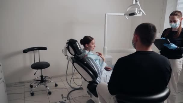 Två Läkare Man Och Kvinna Skyddande Masker Tandvårdsklinik Tjänar Patienten — Stockvideo