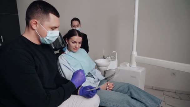 Двоє Лікарів Чоловік Жінка Захисних Масках Стоматологічній Клініці Обслуговують Дівчину — стокове відео