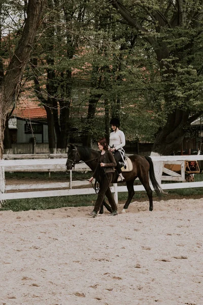 教女孩骑马的女教官 女骑手在马背上练习学习马术 积极的生活方式和休闲活动概念 — 图库照片