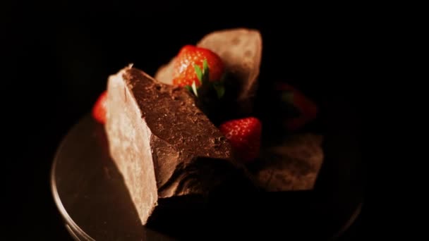 黒の背景にダークチョコレートと赤のイチゴ4K — ストック動画