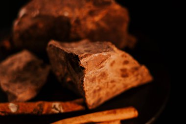 Çikolata. Koyu renkli çikolata parçaları koyu arka planda döner, döner. Gurme tatlı malzemesi. Şekerleme, şekerleme konsepti.