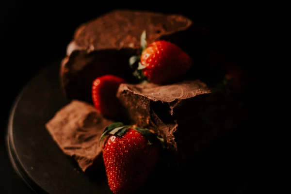 stock image Red straberry with a dark chocolate on a black background 