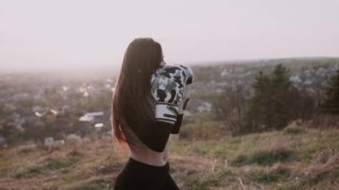 Güzel bayan boksör yazın dağın tepesinde antrenman yapıyor. Boks konsepti.