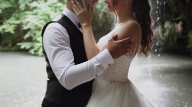 Genç çift aşık gelin ve damat, düğün günü bir dağ şelalesinin yanında. Mutluluğun ve aşkın tadını çıkar.