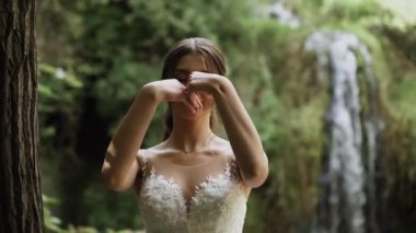 Genç çift aşık gelin ve damat, düğün günü bir dağ şelalesinin yanında. Mutluluğun ve aşkın tadını çıkar.