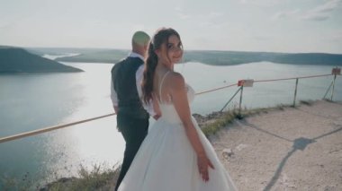 Genç çift kayanın kenarında duruyor. Sevgi. Balayı