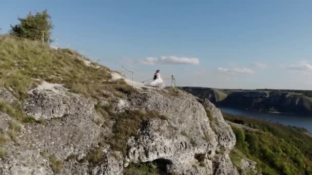 海の上の崖の端に結婚式 花嫁と新郎の高い崖の端に立っている 日没光の空中4Kドローンビデオ — ストック動画