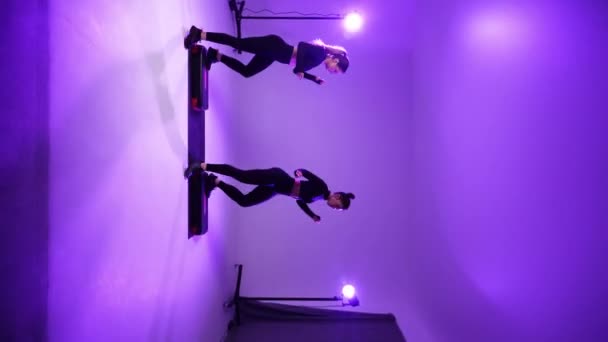 Twee Sportmeisjes Doen Fitness Studio Neon Light Verticale Video — Stockvideo