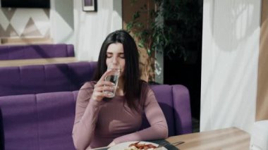 Güzel bir restoranda kahvaltı yapan ve kahve içen bir kadın.