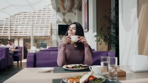 在一家漂亮的餐馆里吃早饭和喝咖啡的女人 — 图库视频影像