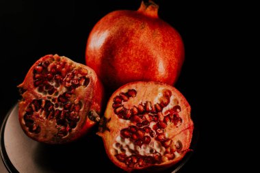 Nar meyvesi. Taze ve olgun nar siyah arka planda dönüyor. Organik Biyolojik Meyveler yakın plan. Diyet, diyet konsepti.