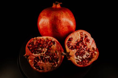 Nar meyvesi. Taze ve olgun nar siyah arka planda dönüyor. Organik Biyolojik Meyveler yakın plan. Diyet, diyet konsepti.