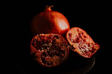Nar meyvesi. Taze ve olgun nar siyah arka planda dönüyor. Organik Biyolojik Meyveler yakın plan. Diyet, diyet konsepti.